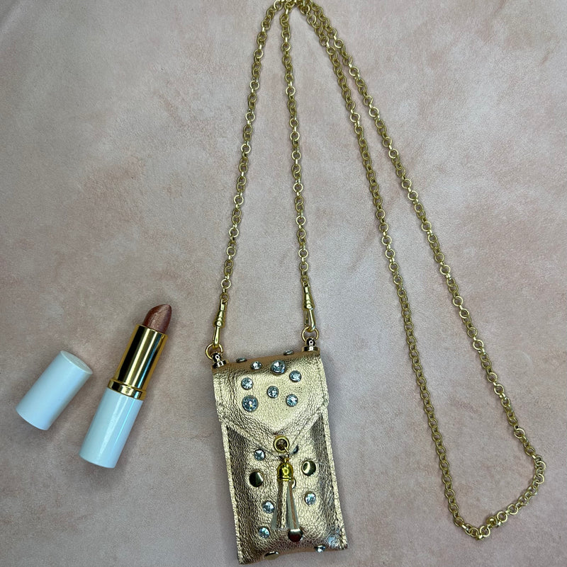 Flat lay of gold leather pouch necklace with long gold chain for your lipstick.