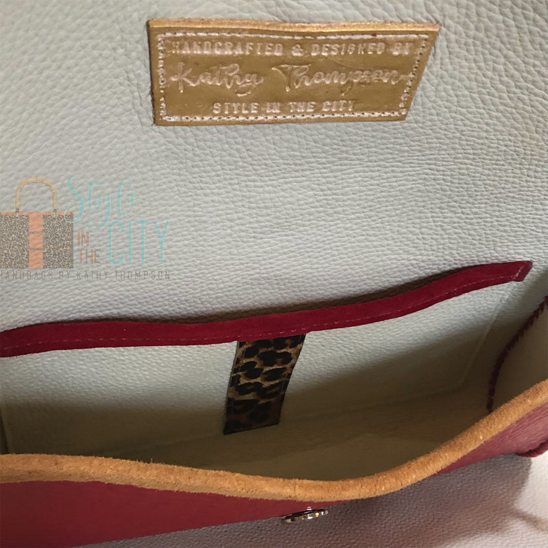 Interior view of leather lining in red leather handbag with leopard trim.